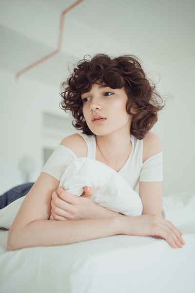 Lie on the bed of a woman wearing a white shirt
